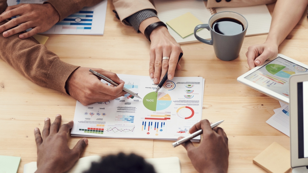 3 people in office looking at document with a chart